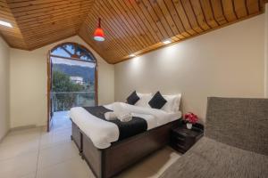 um quarto com uma cama grande e uma janela em The Corner House I Pet friendly & Serviced Villa I Open Air Lawn & Plunge Pool I Bonfire I Dance I Music I Full Party I Kasauli By Exotic Stays em Kasauli