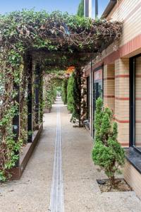 an archway with plants on it next to a building at Urban Lux Colombes in Colombes