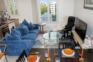 a living room with a blue couch and a table at Urban Lux Colombes in Colombes