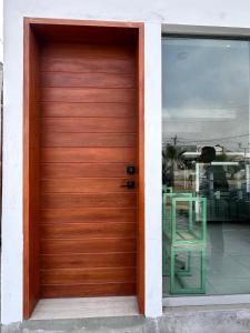 プンタ・エルモサにあるCozy and modern studio close to the beachの窓にテーブルが置かれた木製のガレージドア +2枚の写真