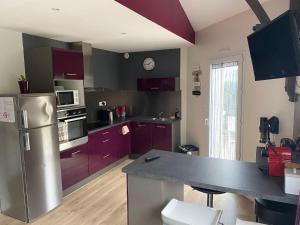 a kitchen with purple cabinets and a counter top at Charmant T3 privé avec vue et accès piscine in Basse-Goulaine