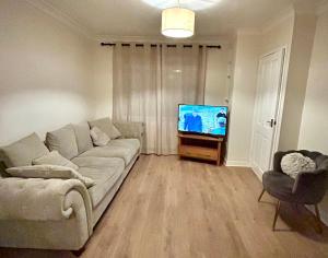 un salon avec un canapé et une télévision à écran plat dans l'établissement Cosy stylish house West Hull, à Hull