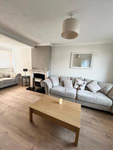 un salon avec deux canapés et une table basse dans l'établissement Cosy stylish house West Hull, à Hull