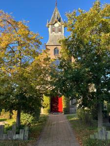 a building with a tower with a red door at De Hoffstee in Minnertsga