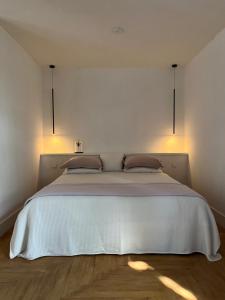 a bedroom with a large white bed with two pillows at De Hoffstee in Minnertsga