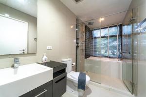 a bathroom with a sink and a shower and a toilet at Elegant 1BR Garden-View Condo - The Deck Patong in Patong Beach +16 photos