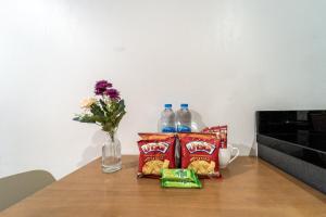 a table with two bottles of water and chips and a vase of flowers at Elegant 1BR Garden-View Condo - The Deck Patong in Patong Beach