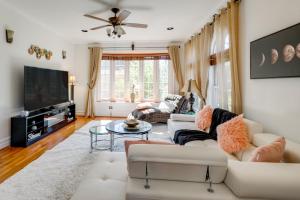 a living room with white furniture and a flat screen tv at Take Metro to DC! Family Home in Springfield in Franconia