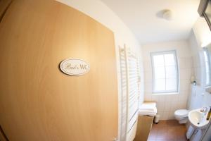 a bathroom with a toilet and a sign on the wall at Apartment in Prerow with terrace & close to the beach in Prerow