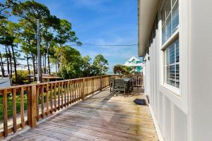 eine Holzterrasse mit einer Bank an der Seite eines Hauses in der Unterkunft Baydream Believer in Fort Morgan