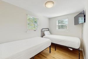 zwei Betten in einem Zimmer mit zwei Fenstern in der Unterkunft Baydream Believer in Fort Morgan