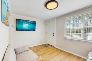 ein Wohnzimmer mit einem Sofa und einem Fernseher an der Wand in der Unterkunft Baydream Believer in Fort Morgan