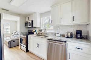 eine Küche mit weißen Schränken und einer Arbeitsplatte in der Unterkunft Baydream Believer in Fort Morgan