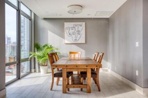 ein Esszimmer mit einem Holztisch und Stühlen in der Unterkunft Blueground Long Island City rooftop nr Gantry Park NYC-1767 in Long Island City