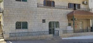 a brick building with a door and a balcony at Petra Luminous Apartment in Wadi Musa
