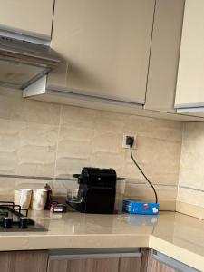 a kitchen with a counter top with a stove and a charger at roeya résidence in Nador +11 photos