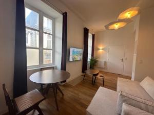 a living room with a table and a couch at Hyper Centre Cathédrale Boulingrin 101 in Reims