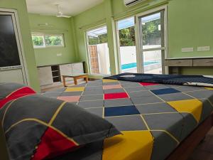 a bedroom with a large colorful bed in a room with windows at Maple Dreams Retreat- A Pool side Villa in Pondicherry