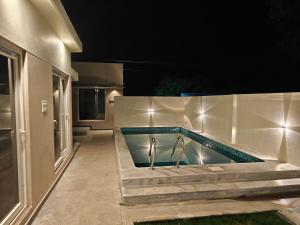 a swimming pool with lights on the side of a house at Maple Dreams Retreat- A Pool side Villa in Pondicherry