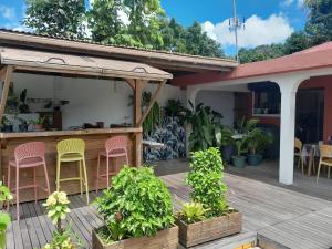 Un patio con sillas rosas y amarillas en una terraza. en Maison atypique avec vue unique, en Le Carbet