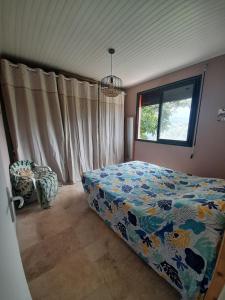 un dormitorio con una cama y una ventana en Maison atypique avec vue unique, en Le Carbet