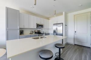 a kitchen with white cabinets and a counter and stools at Blueground Del Valle pool nr McKinney Falls ATX-353 in Austin