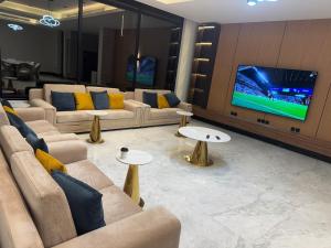 a living room with couches and a flat screen tv at Villa, 6BR with swimming pool next to Stars avenue in Jeddah