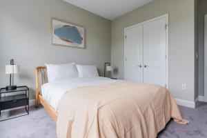 a bedroom with a large white bed and a table at Blueground Bethesda fitness center nr Park WDC-1191 in Bethesda