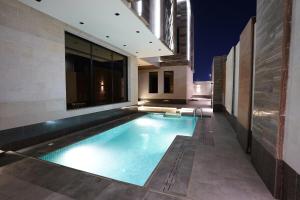 a swimming pool on the side of a building at Villa, 6BR with swimming pool next to Stars avenue in Jeddah