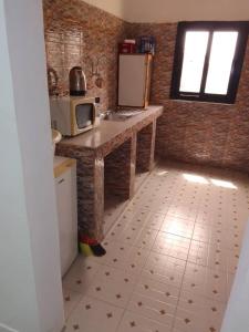 cocina con encimera, fregadero y microondas en Keur Vieux DIATTA, en Ziguinchor