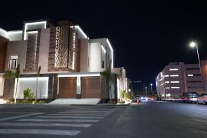 a building on a street at night with a parking lot at Villa, 6BR with swimming pool next to Stars avenue in Jeddah