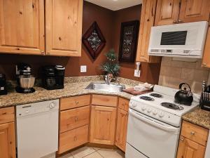 a kitchen with a white stove and a sink at Alpenglow One Bedroom One Bath – A09 in Ouray
