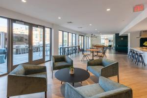a lobby with couches and tables and a bar at Blueground Newtonville fitness center nr Crystal Lake BOS-1239 in Newton
