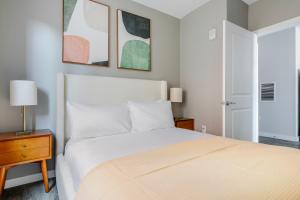 a bedroom with a white bed and two lamps and a door at Blueground Central Square rooftop nr Harvard BOS-1258 in Cambridge