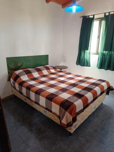 a bedroom with a bed with a checkered blanket at Bosquecito de Carpin in Carpintería +34 photos