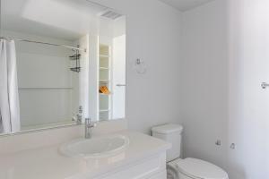 Un baño blanco con lavabo e inodoro. en Blueground Downtown Berkeley rooftop nr UC Berkeley SFO-1984, en Berkeley 21 fotos más
