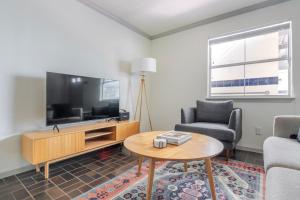 Una sala de estar con un televisor y una mesa. en Blueground Downtown Austin pool nr Congress ATX-341, en Austin