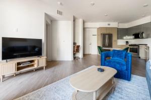 Una sala de estar con un sofá azul y un televisor en Blueground East Industrial pool nr Lake Elizabeth SFO-2000, en Warm Springs District