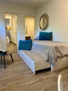 a bedroom with a bed with blue pillows and a mirror at LÁZARO Suites in Monterrey +44 photos