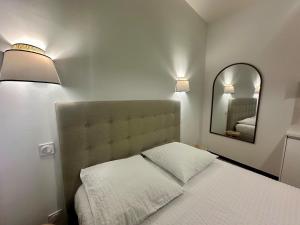 a small bedroom with a bed and a mirror at Hyper Centre Cathédrale Boulingrin 102 in Reims +2 photos