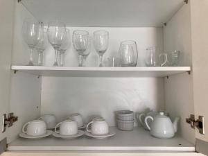 a shelf with wine glasses and dishes on it at Studio Shine - Apartamento inteiro para COP in Belém
