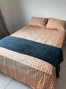 a wicker bed with a blue blanket on it at Studio Shine - Apartamento inteiro para COP in Belém