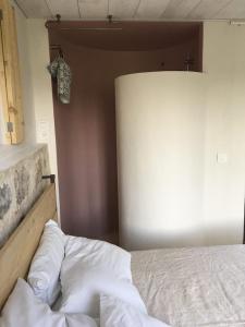 a bedroom with a bed with white sheets on it at Maison du Paradis in Alès