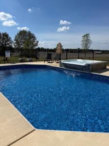 a swimming pool with blue water in front of a fence at Barren Breeze Bed and Breakfast in Lucas