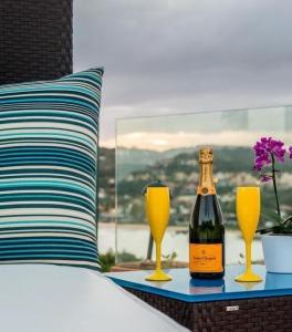 a bottle of champagne and two glasses on a bed at Mar Búzios inn in Búzios