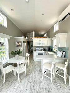 a kitchen with white chairs and a table and a counter at New Tiny Home- Paddle Boards, Kayaks, Pool, Marina in Key Largo