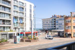 a city street with buildings and a car on the road at Plaza in Sint-Idesbald
