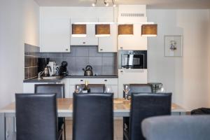 a kitchen with a wooden table and chairs at Plaza in Sint-Idesbald