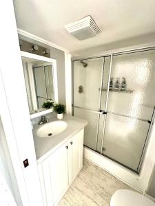 a white bathroom with a sink and a shower at New Tiny Home- Paddle Boards, Kayaks, Pool, Marina in Key Largo