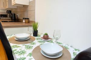 a dining table with two plates and glasses on it at Stunning Studio2, Banstead with free off st parking in Banstead